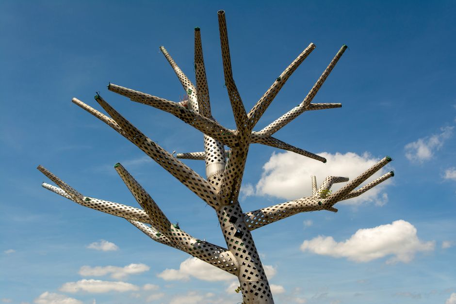 Tuinhuis met metalen details en groene planten.